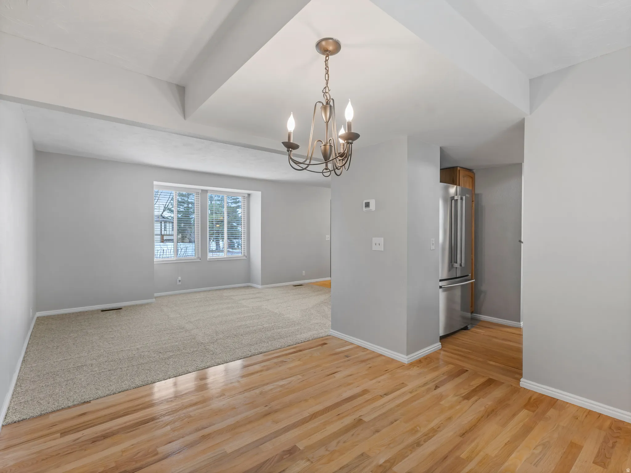 Spare room featuring suspended lighting and light wood finished floors