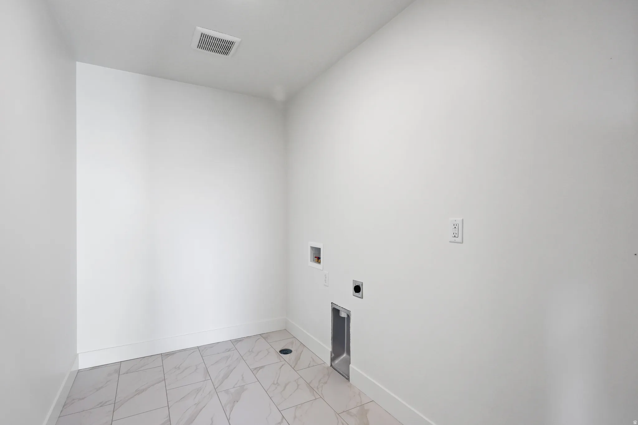 Washroom featuring hookup for a washing machine, light marble finish flooring, and electric dryer hookup
