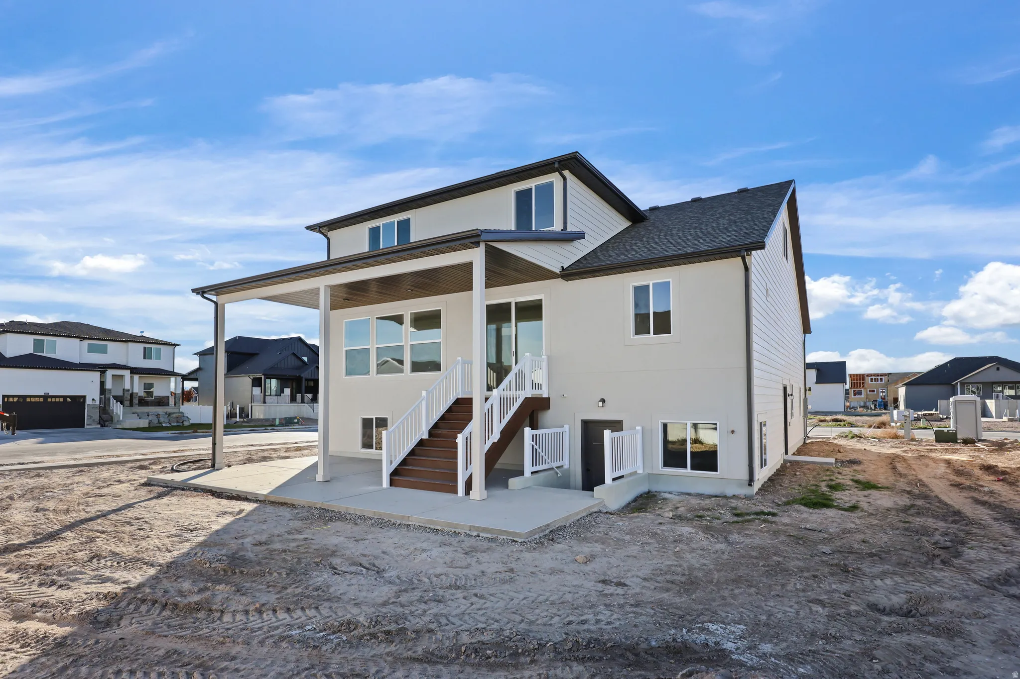 Back of property with a patio area and a shingled roof