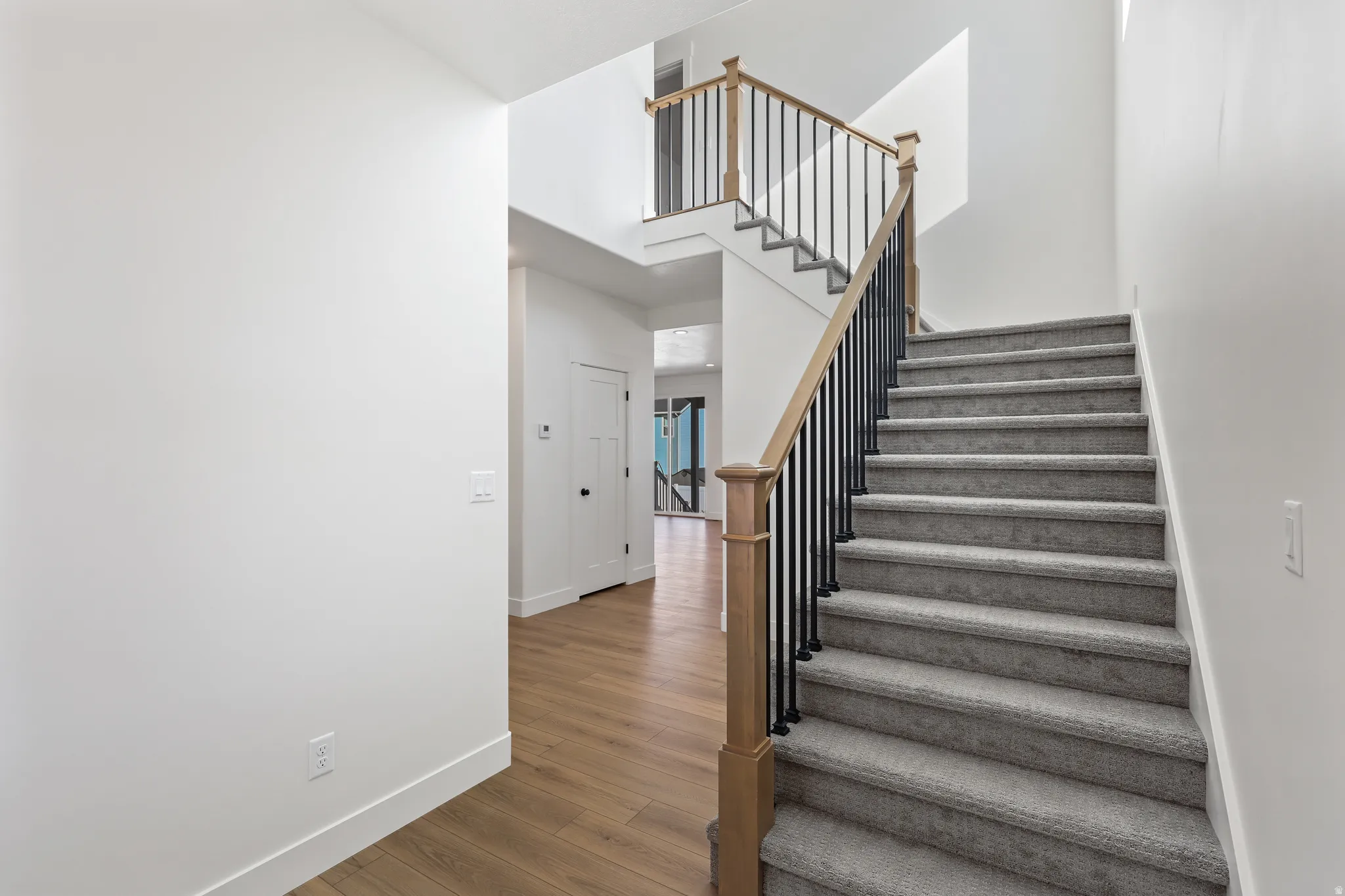 Staircase with wood finished floors and a towering ceiling