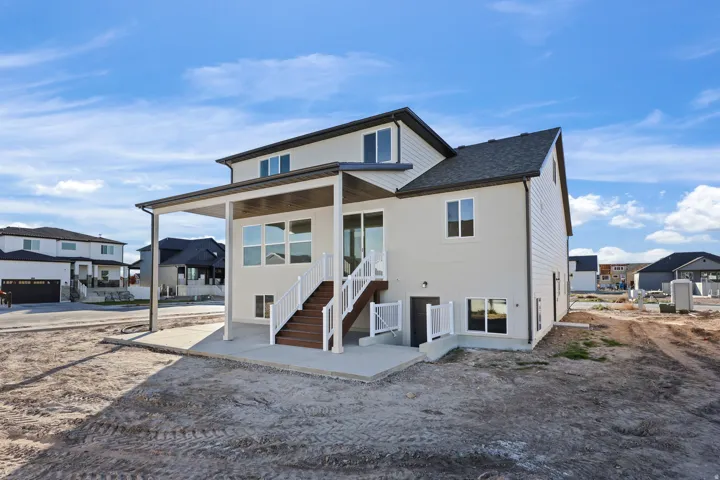 Back of property with a patio area and a shingled roof
