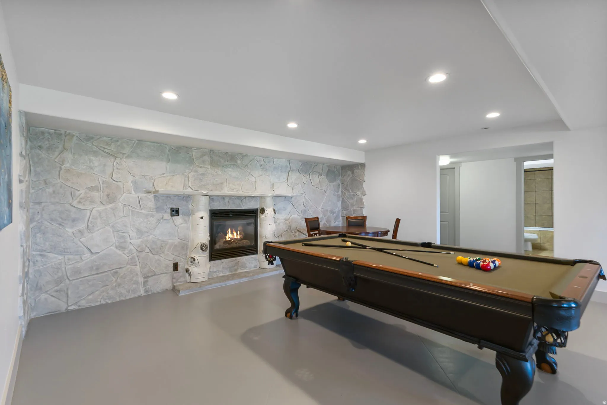 Recreation room featuring a stone fireplace, billiards, and recessed lighting