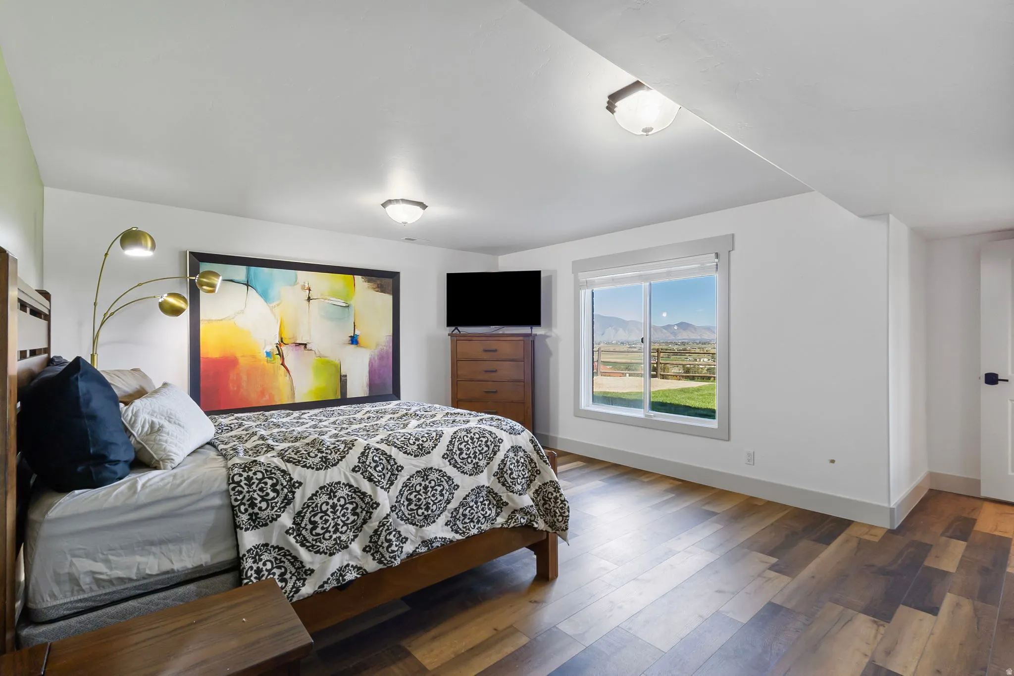 Bedroom with valley and mountain views from window.
