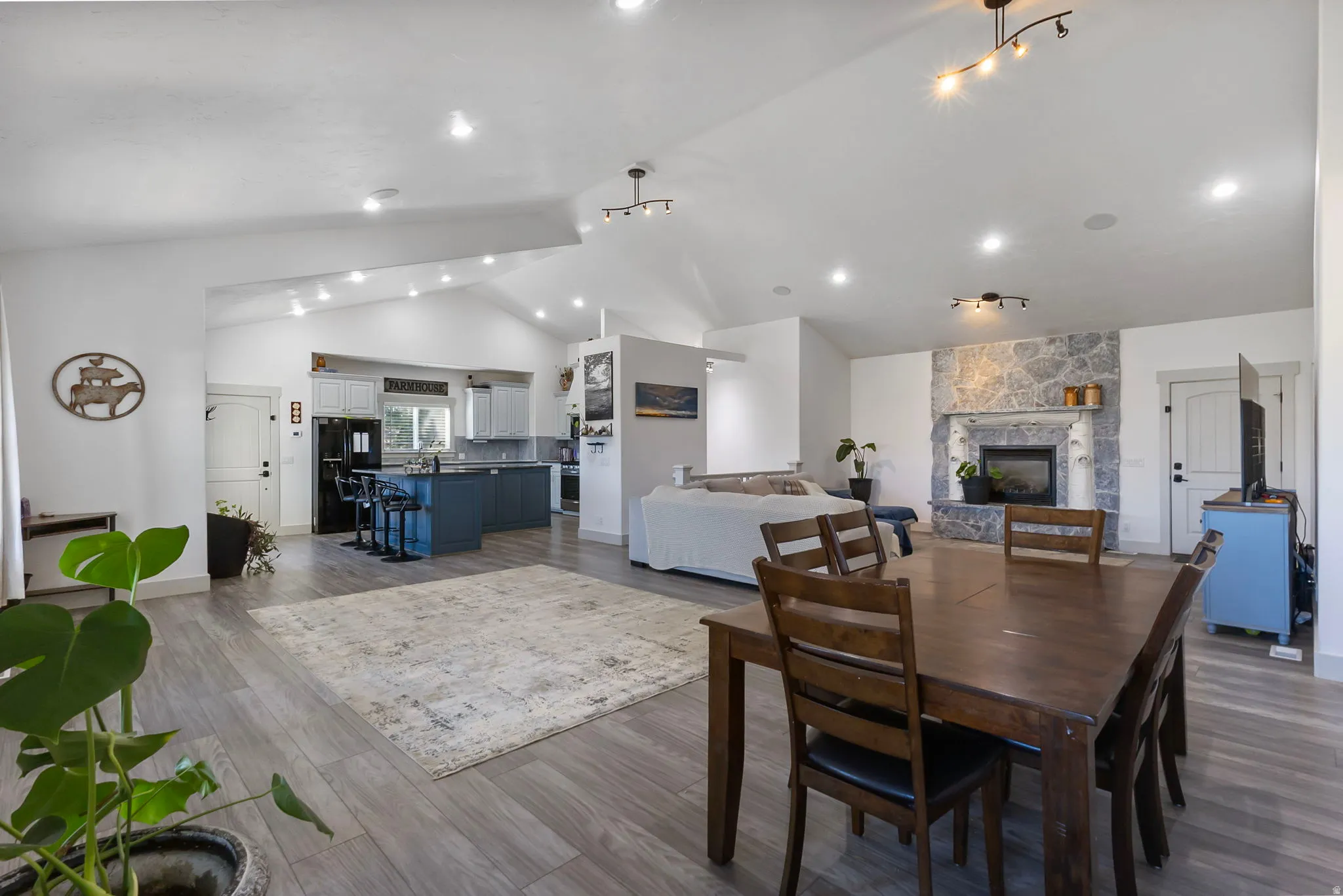 Dining space featuring high vaulted ceiling, and a stone fireplace