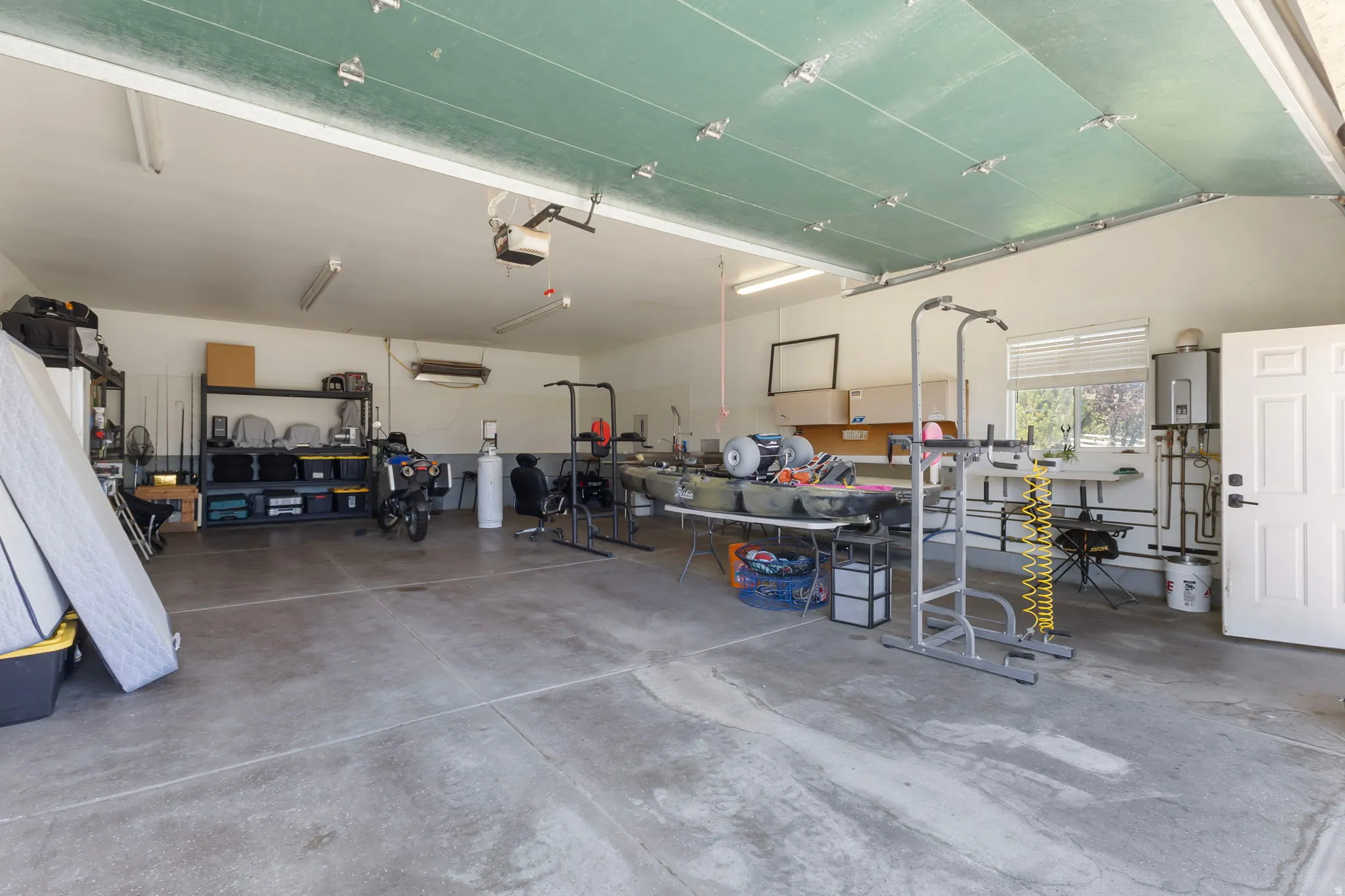 28 X 39 Detached garage featuring a sink, kennel access and tankless water heater.