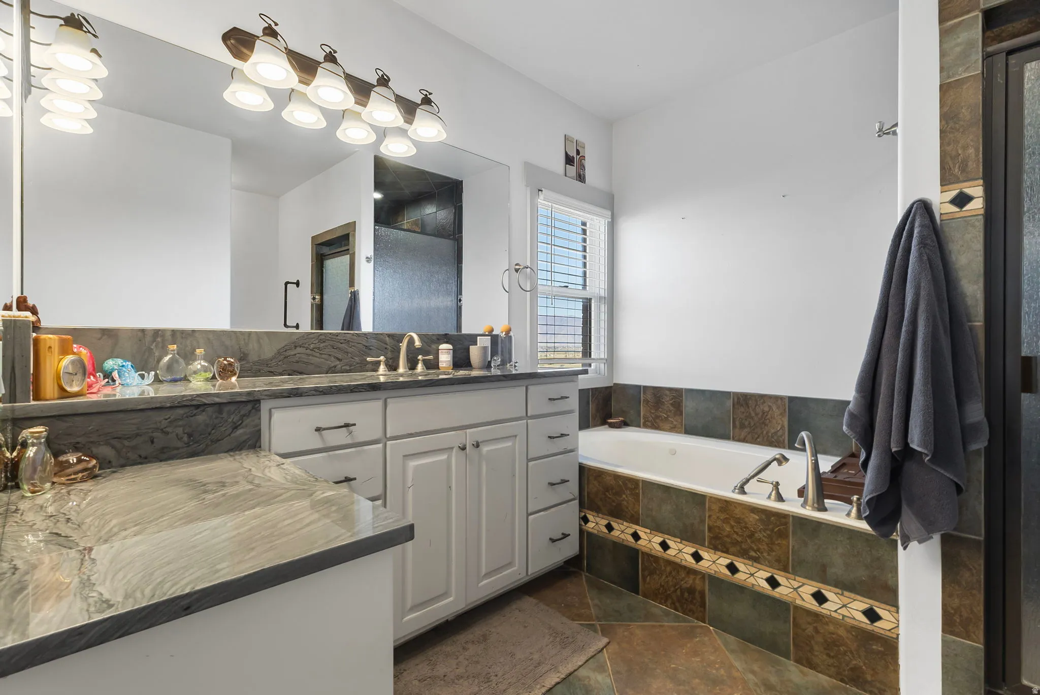 Primary bathroom featuring a garden tub, separate shower and a Quartzite countertop vanity with built in makeup vanity.