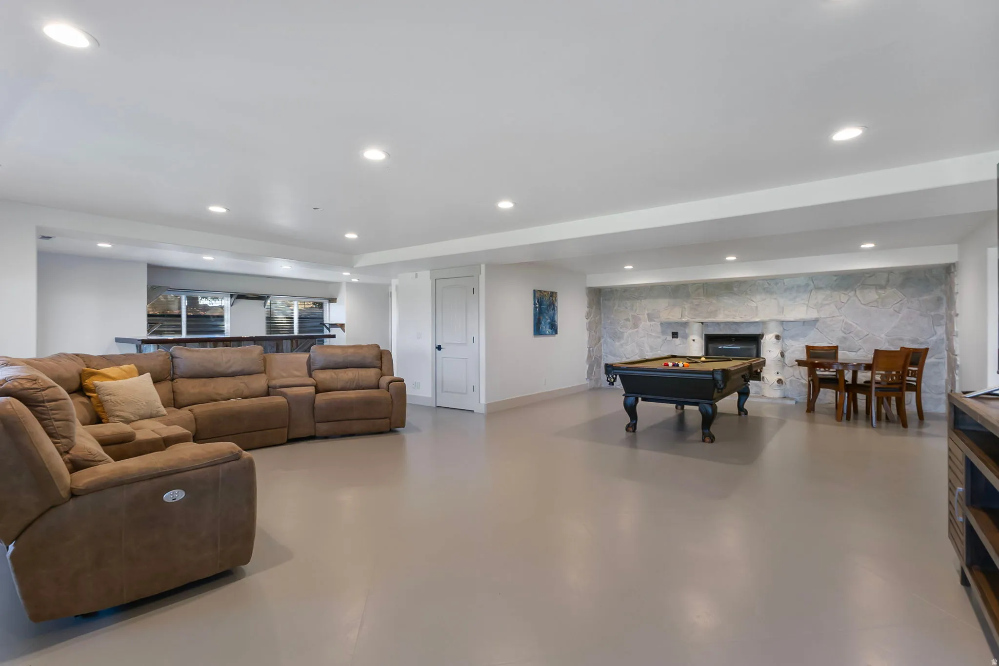 Recreation room with billiards table, recessed lighting and a stone fireplace