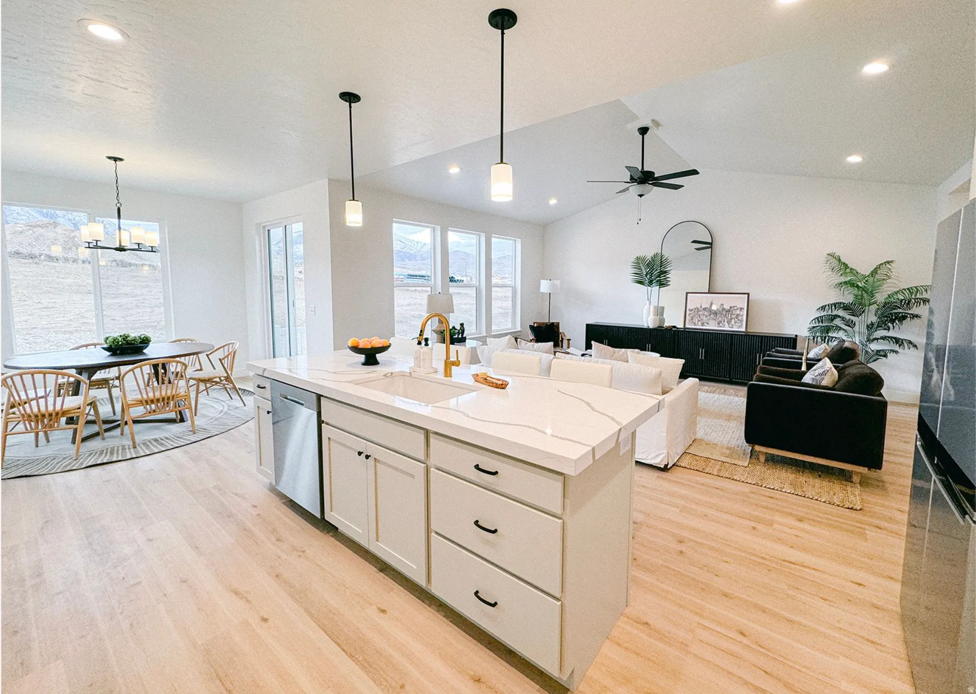 Kitchen featuring light wood-style floors, a kitchen island with sink, stainless steel appliances, light stone countertops, and open floor plan