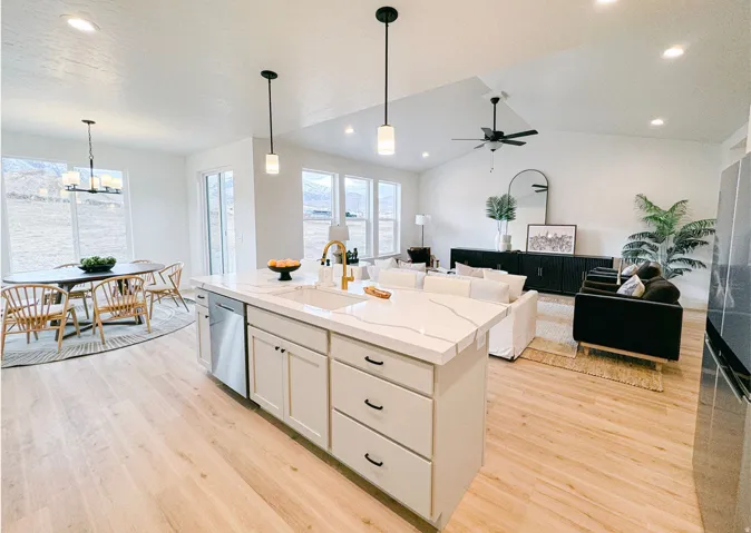 Kitchen featuring light wood-style floors, a kitchen island with sink, stainless steel appliances, light stone countertops, and open floor plan