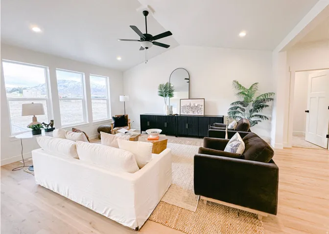 Living room with light wood-style flooring, vaulted ceiling, ceiling fan, recessed lighting, and a mountain view