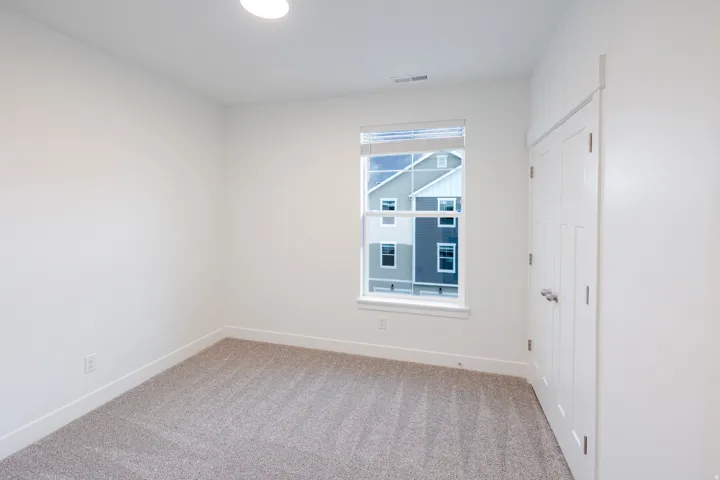 Unfurnished bedroom featuring light carpet and baseboards