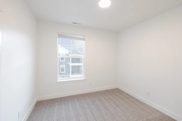 Unfurnished room with light carpet and baseboards