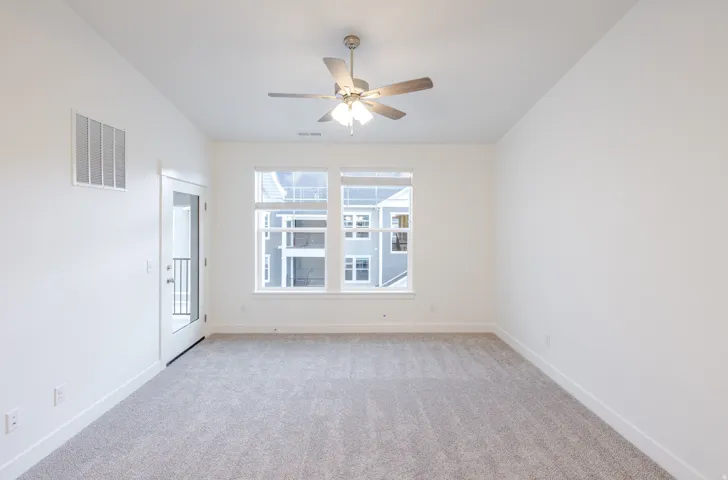 Spare room featuring light colored carpet and ceiling fan