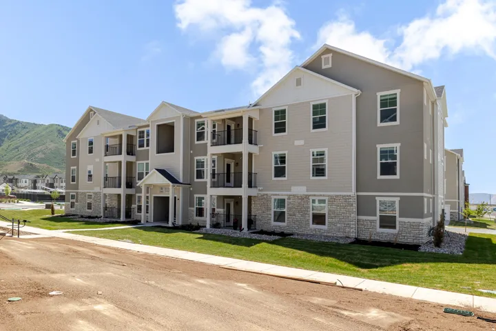 Modern multi-story building featuring light-toned siding and stone accents