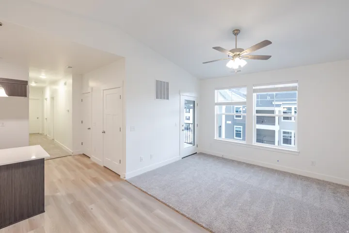 Empty room featuring lofted ceiling, light wood-style floors, and a ceiling fan