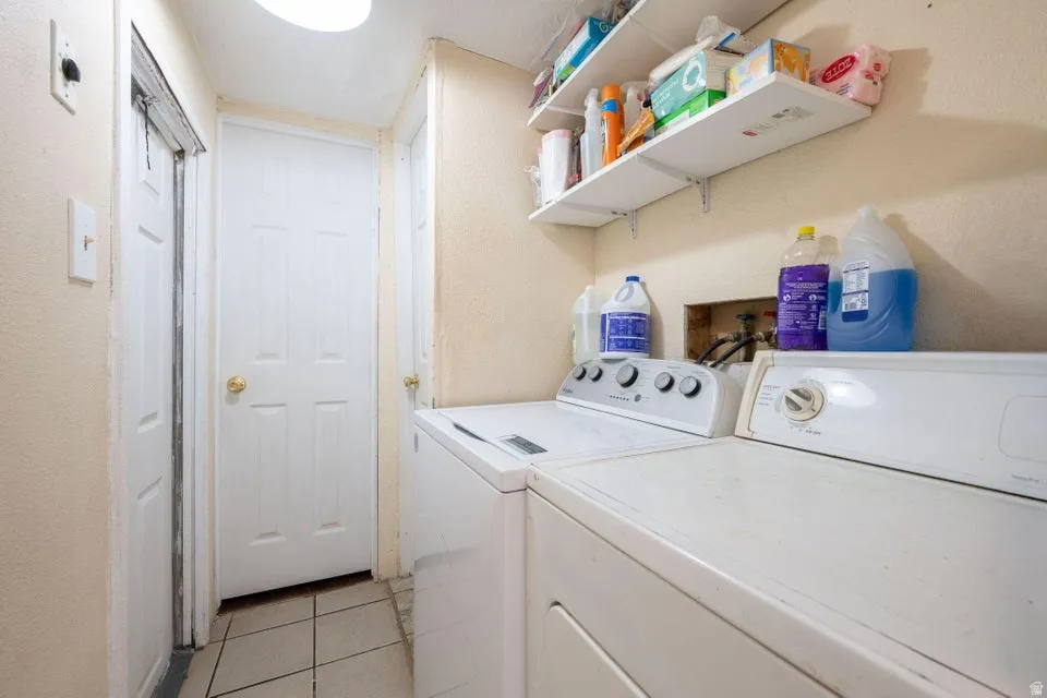Laundry room featuring light tile patterned flooring and washing machine and dryer