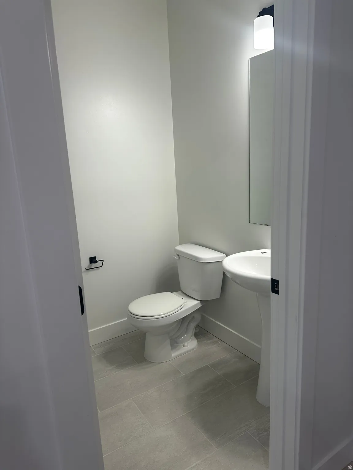 Bathroom featuring baseboards and light tile patterned floors