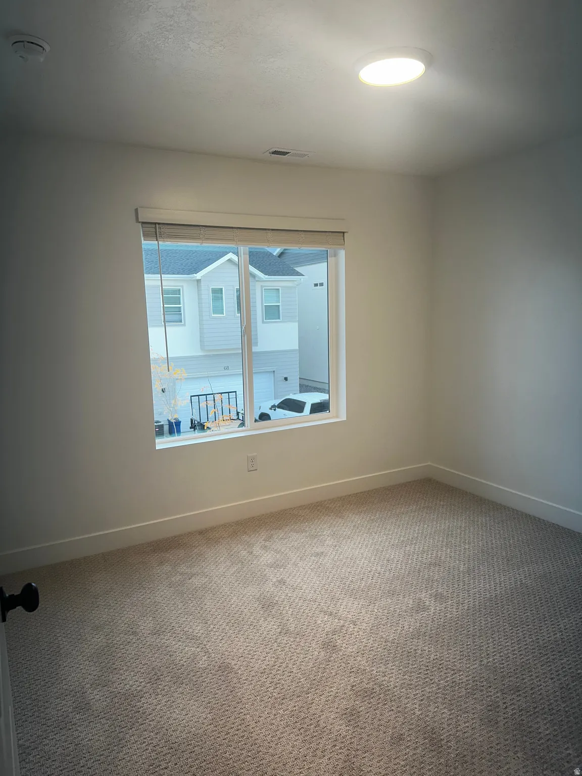 Spare room featuring carpet floors and a smoke detector