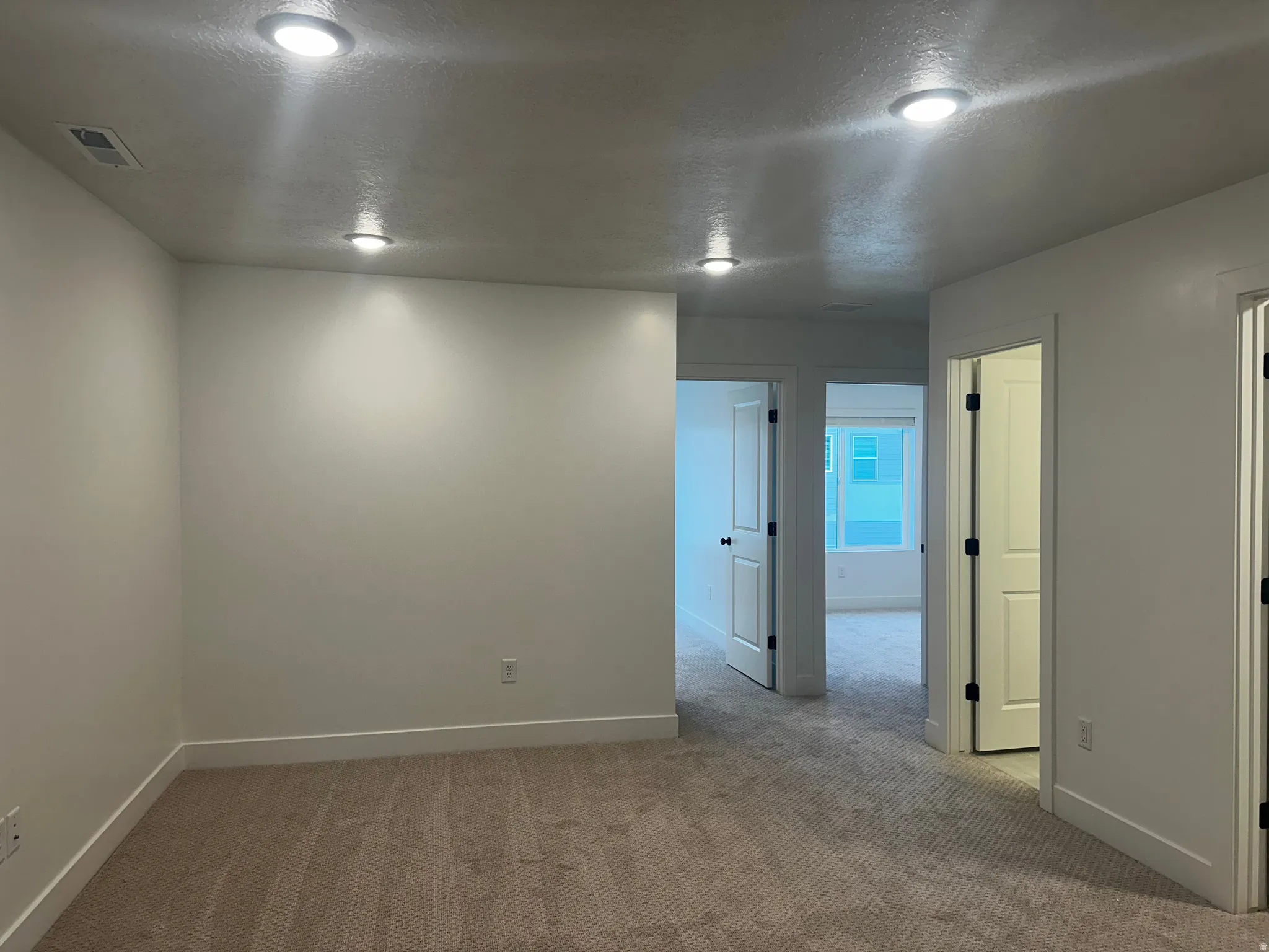 Unfurnished room featuring a textured ceiling and carpet flooring