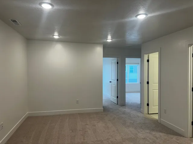 Unfurnished room featuring a textured ceiling and carpet flooring