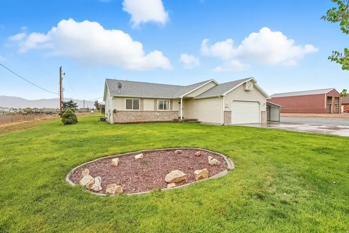 Ranch-style home featuring a front yard, concrete driveway, brick siding, and roof with shingles