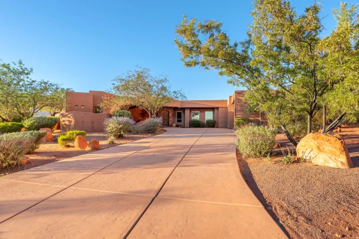 Pueblo revival-style home featuring driveway and stucco siding