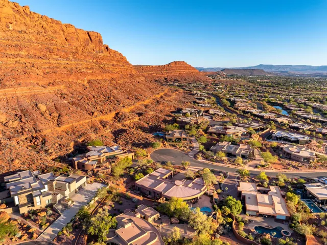 Aerial view of property and surrounding area with mountains and nearby suburban area