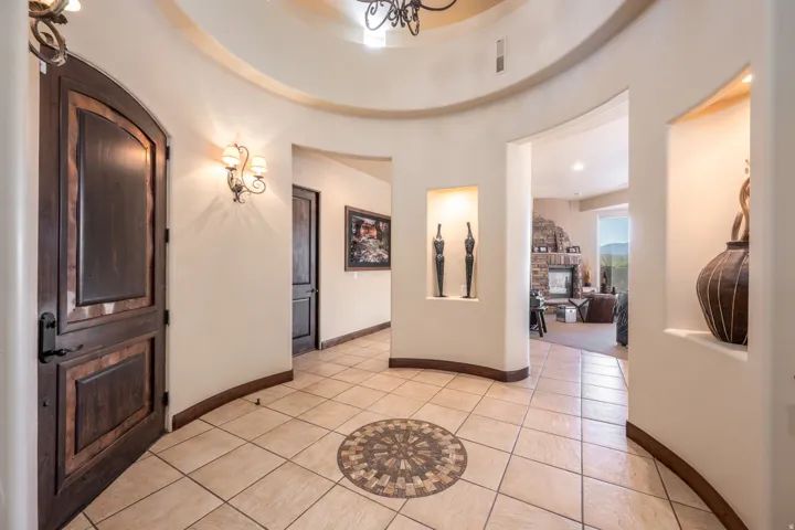 Entrance foyer with light tile patterned flooring, a fireplace, a chandelier, and recessed lighting