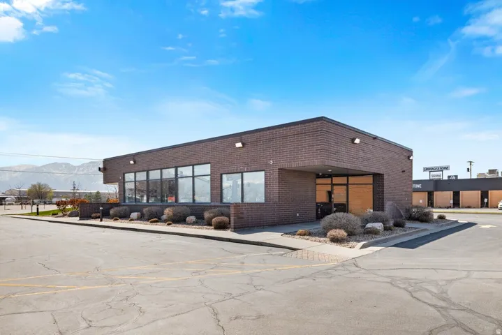 View of building exterior featuring a mountain view and uncovered parking