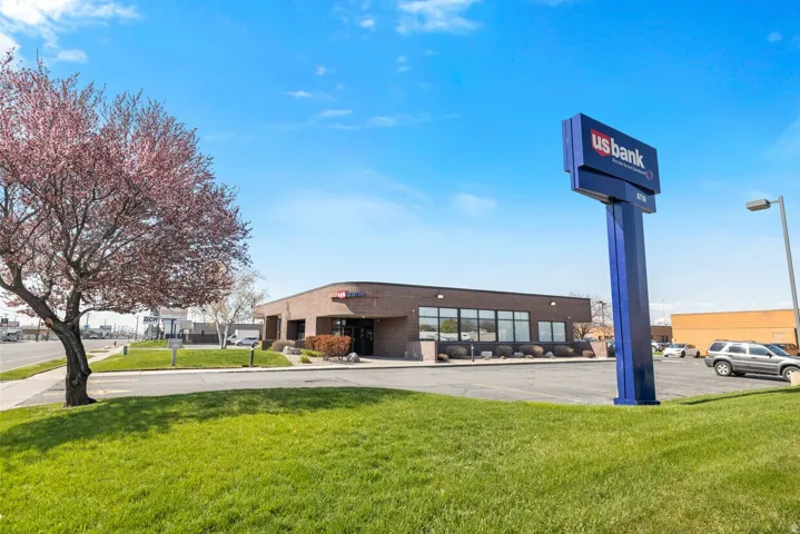 Surrounding community with a lawn and uncovered parking