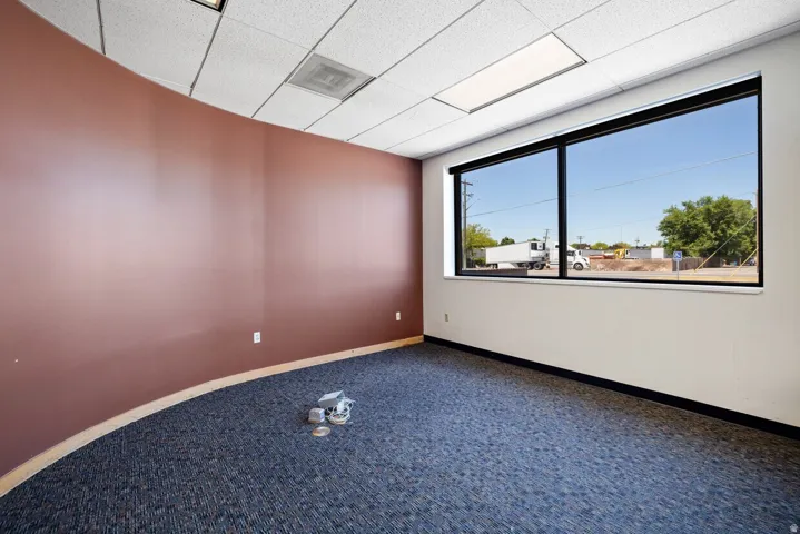 Carpeted spare room with baseboards and a paneled ceiling