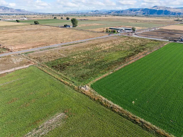 Aerial view of sparsely populated area featuring mountains and large plots for crops