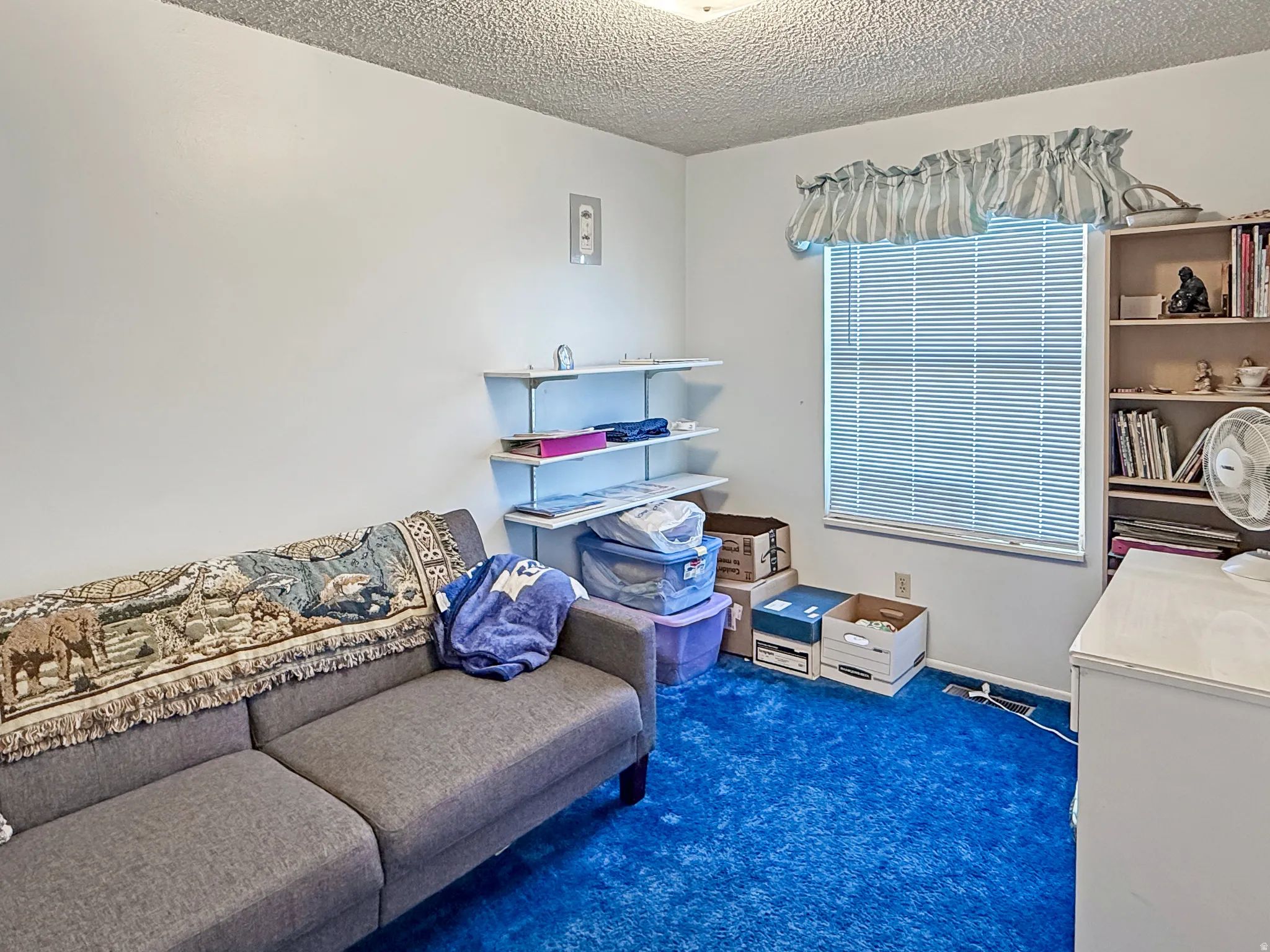 Office area with dark carpet and a textured ceiling