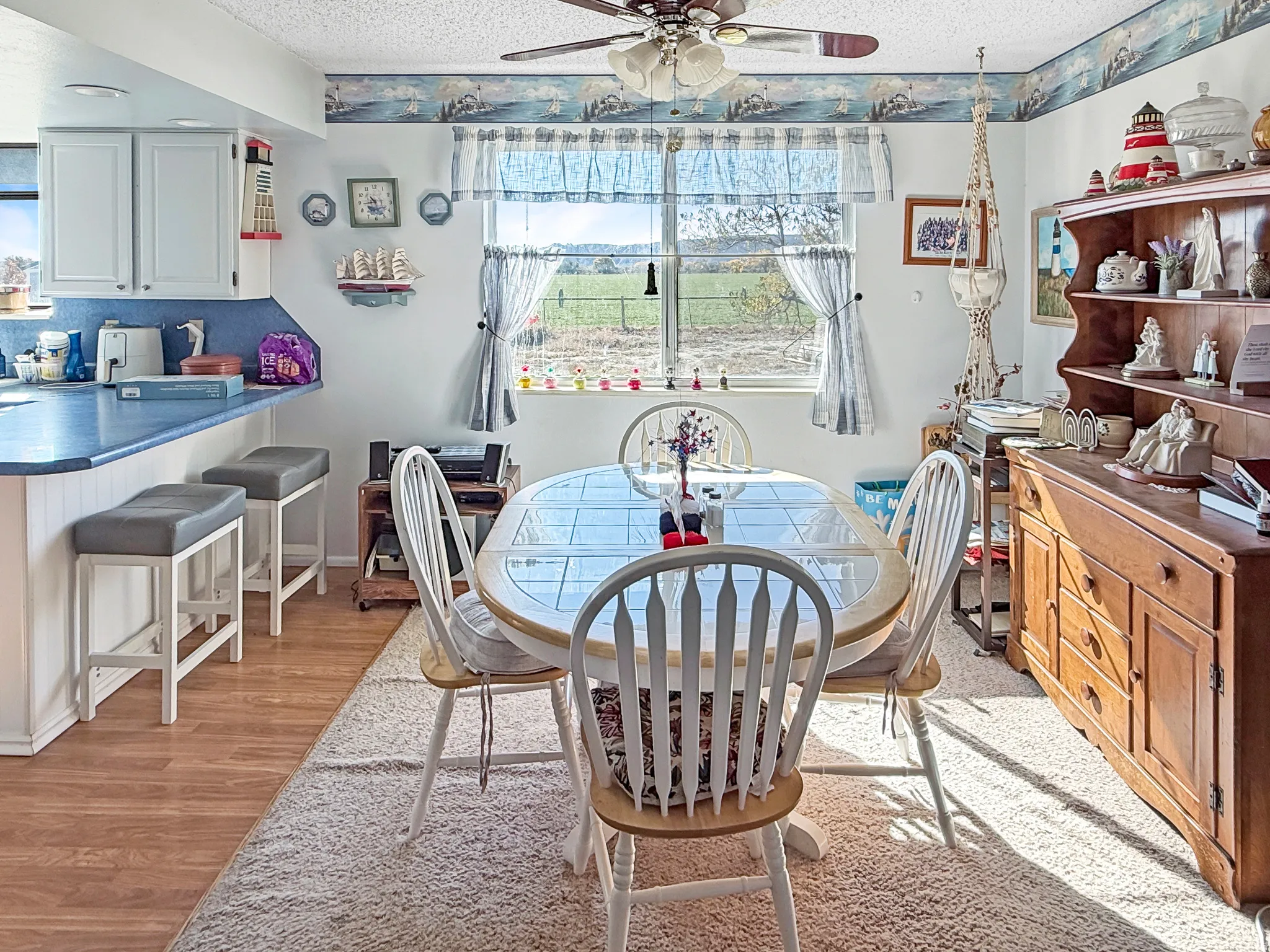 Dining space featuring a textured ceiling, light wood-style flooring, and a ceiling fan