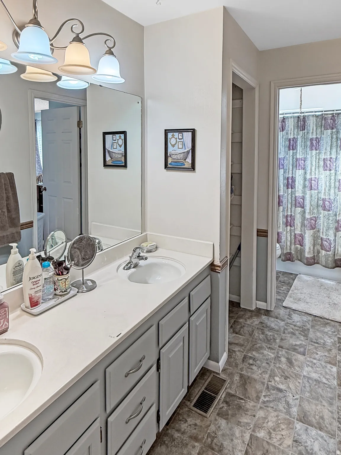 Bathroom featuring double vanity and stone finish flooring