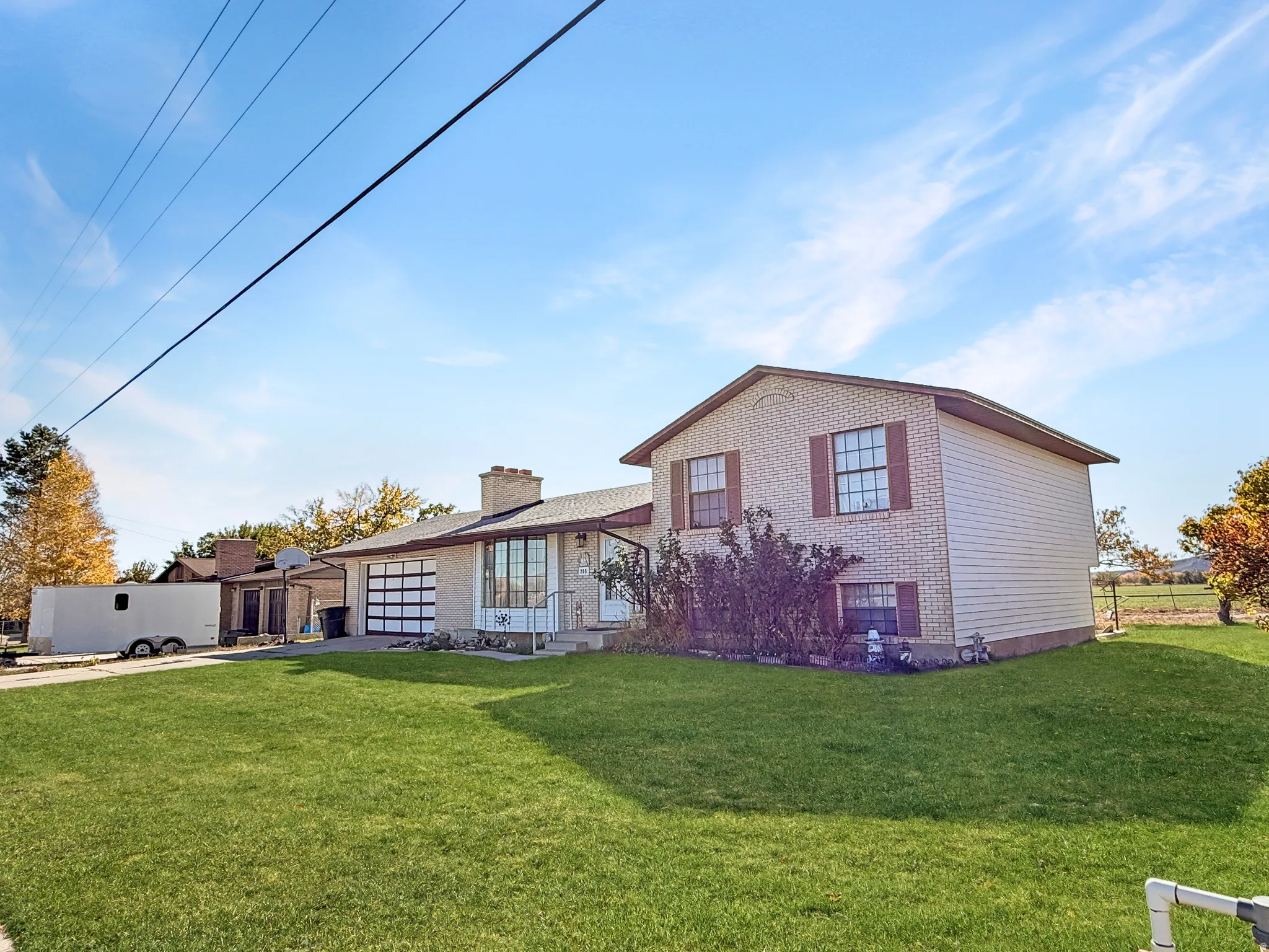 Rear view of property featuring a yard, brick siding, and driveway