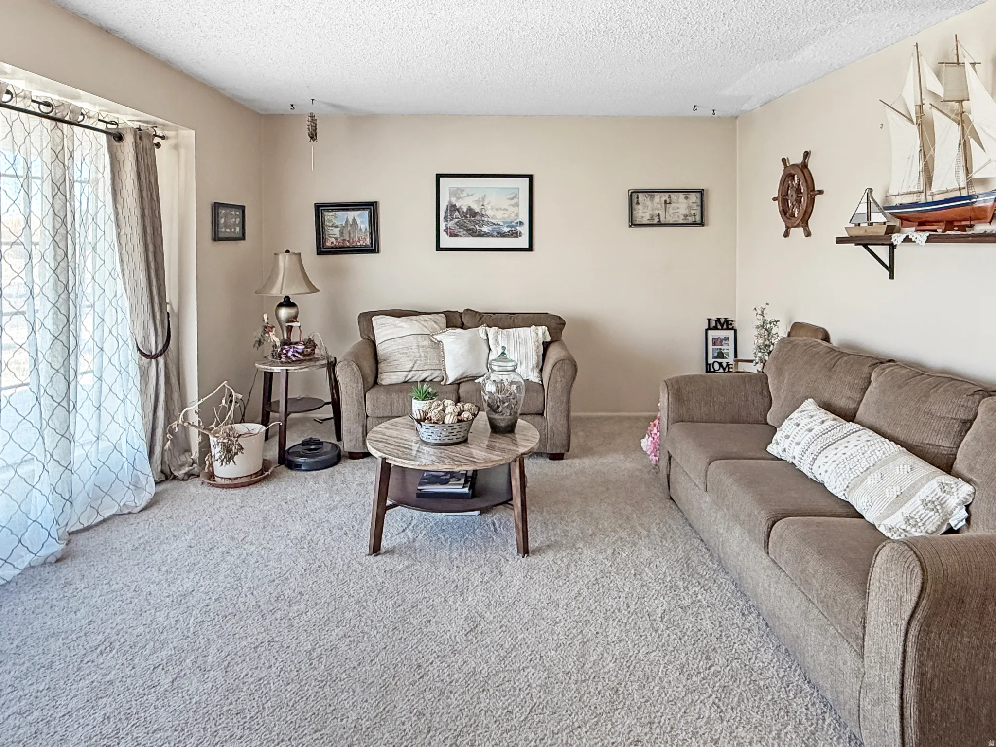 Carpeted living room with a textured ceiling