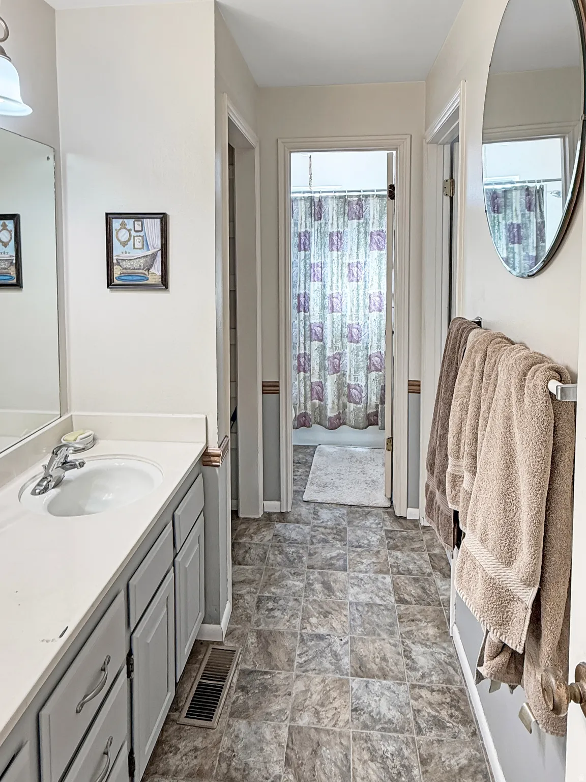 Bathroom with vanity, stone finish flooring, and a shower with curtain