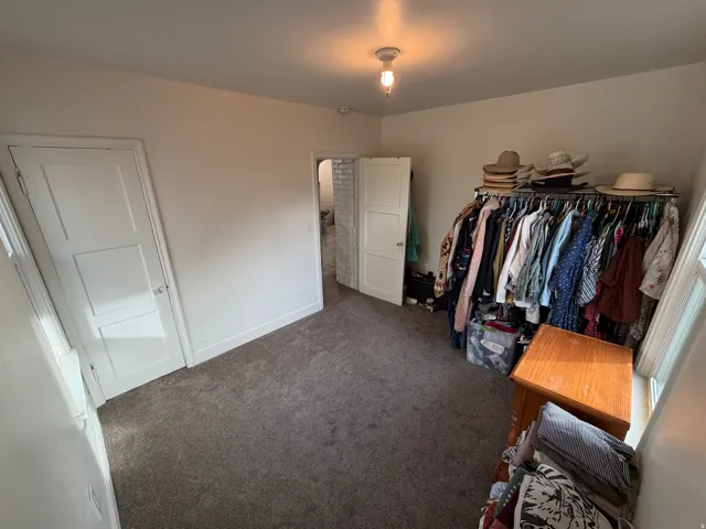 Spacious bedroom featuring carpet floors and two windows.