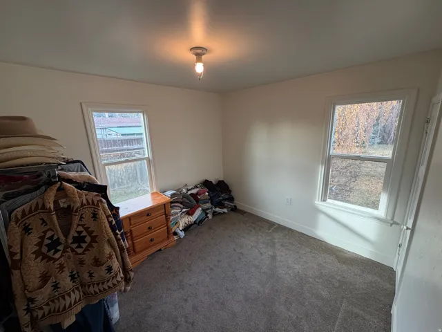 Carpeted bedroom with multiple windows.