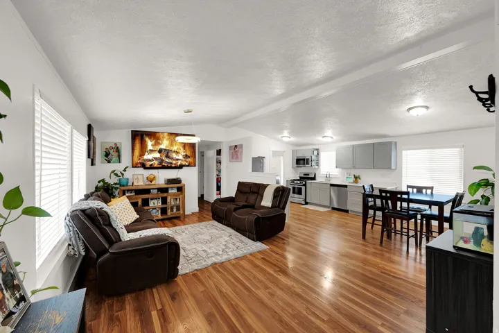 Living room with healthy amount of natural light, light wood-style floors, and a textured ceiling