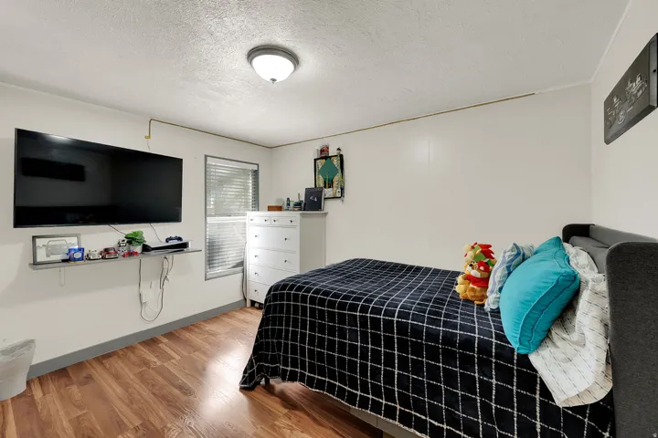 Bedroom with light wood finished floors and a textured ceiling