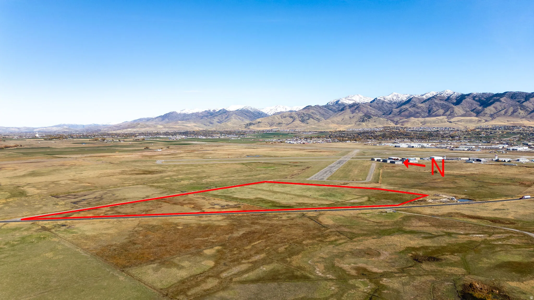Aerial view of property and surrounding area featuring property boundaries highlighted, rural landscape, and mountains