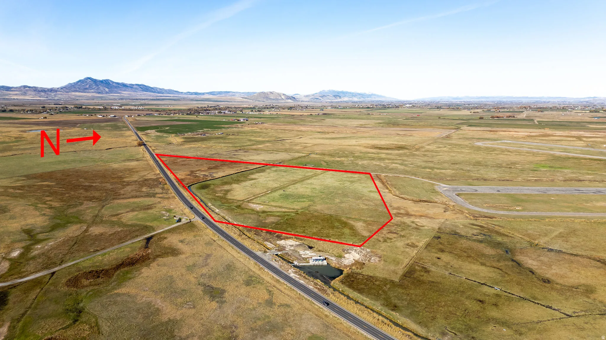 Overview of rural landscape featuring property parcel outlined and a mountain backdrop