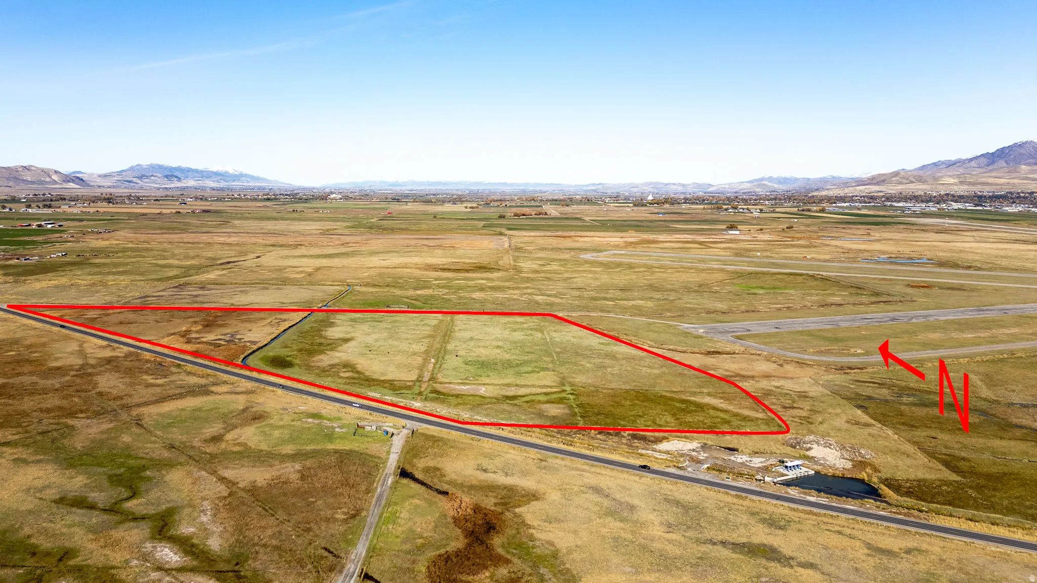 Aerial view of sparsely populated area featuring property parcel outlined and mountains