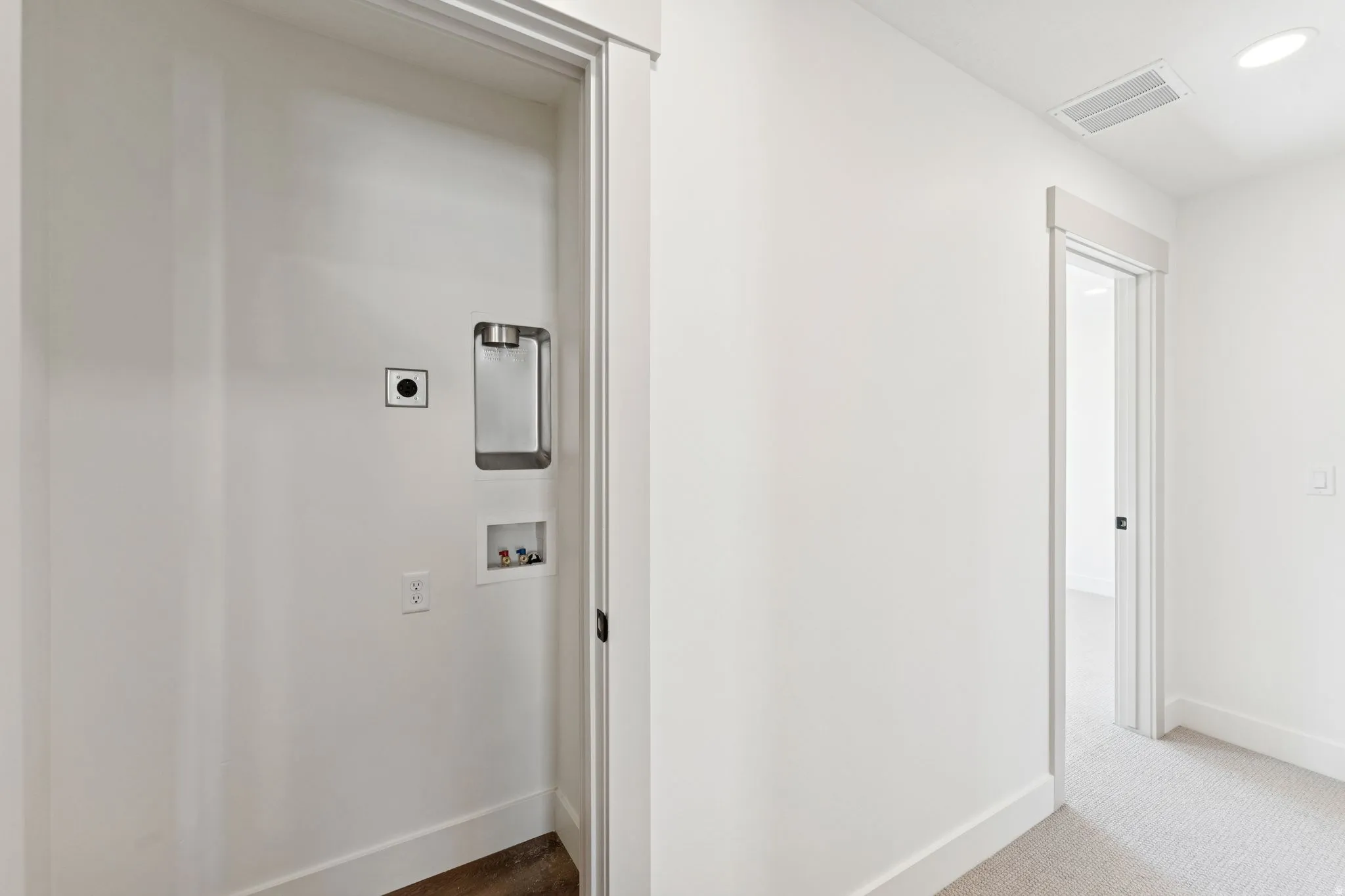 Hallway with dark carpet and recessed lighting
