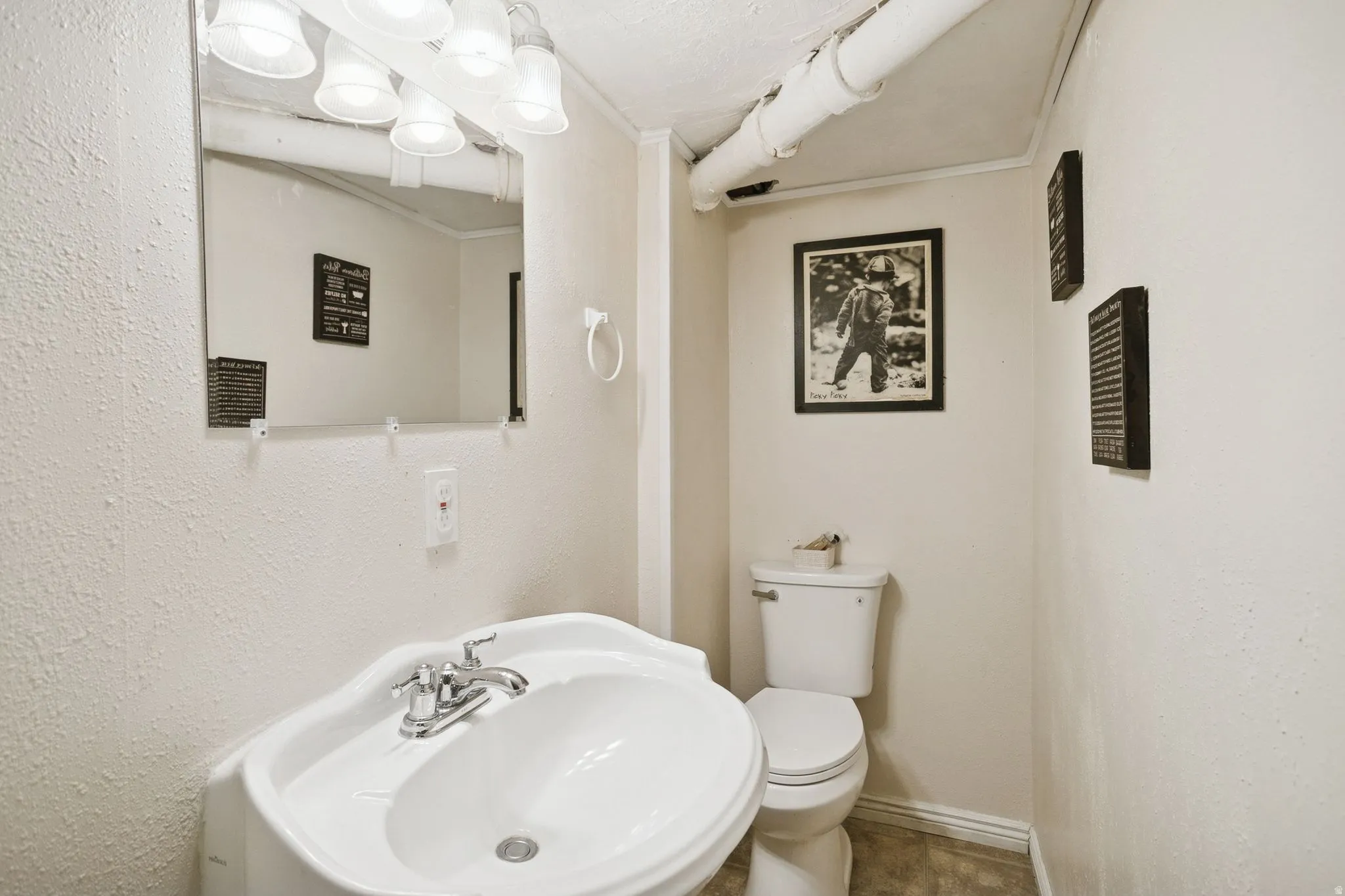 Half bath featuring a sink and crown molding