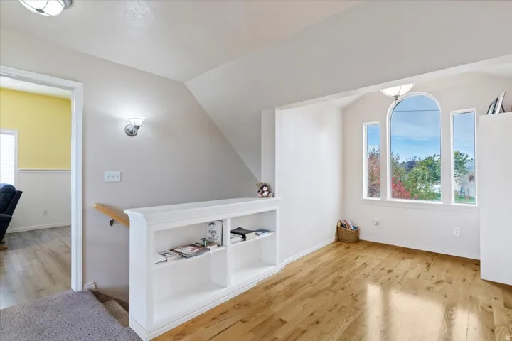 Bonus room featuring light wood-style floors and lofted ceiling