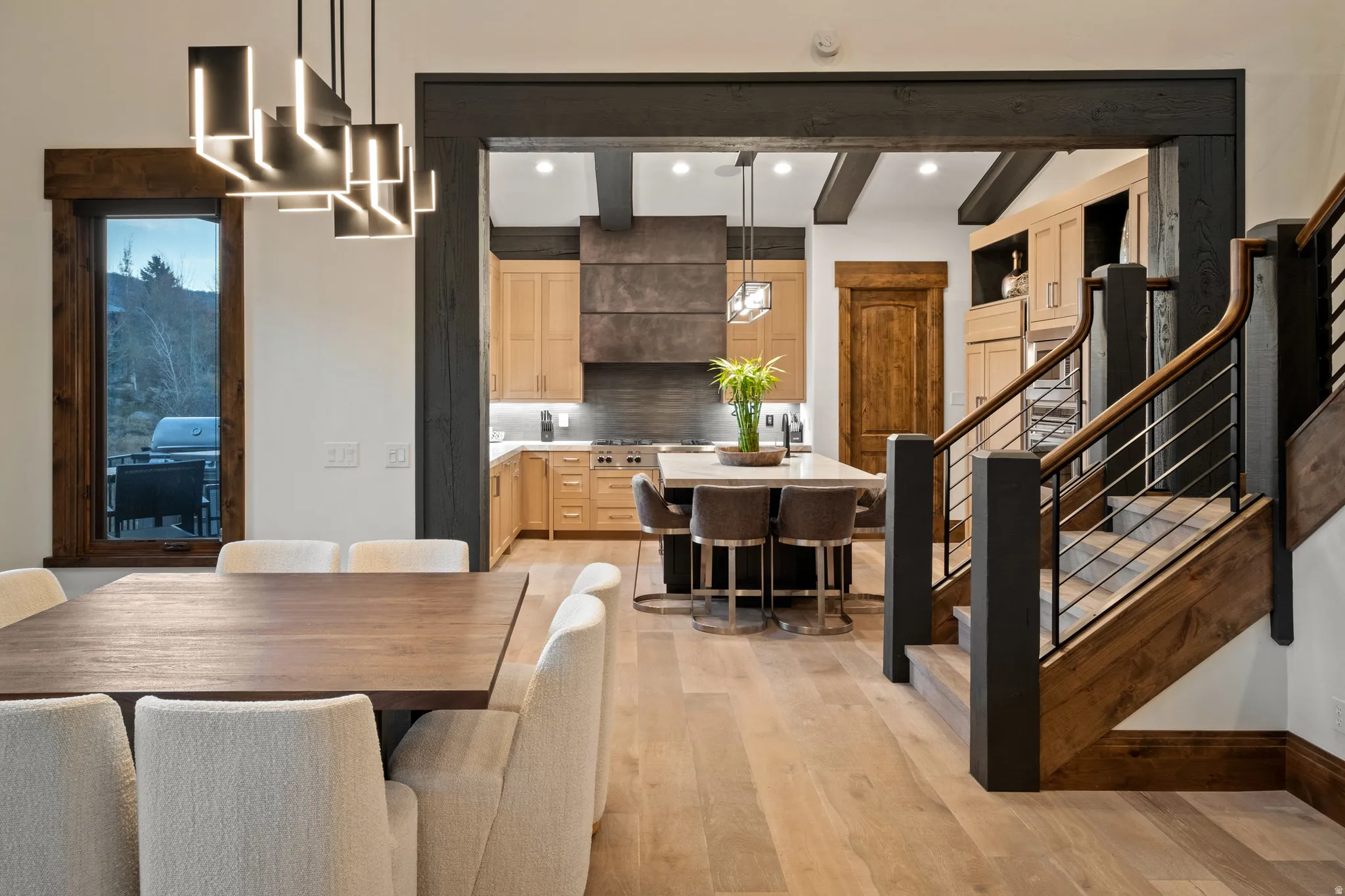 Dining area with beam ceiling, light wood-style flooring, and recessed lighting