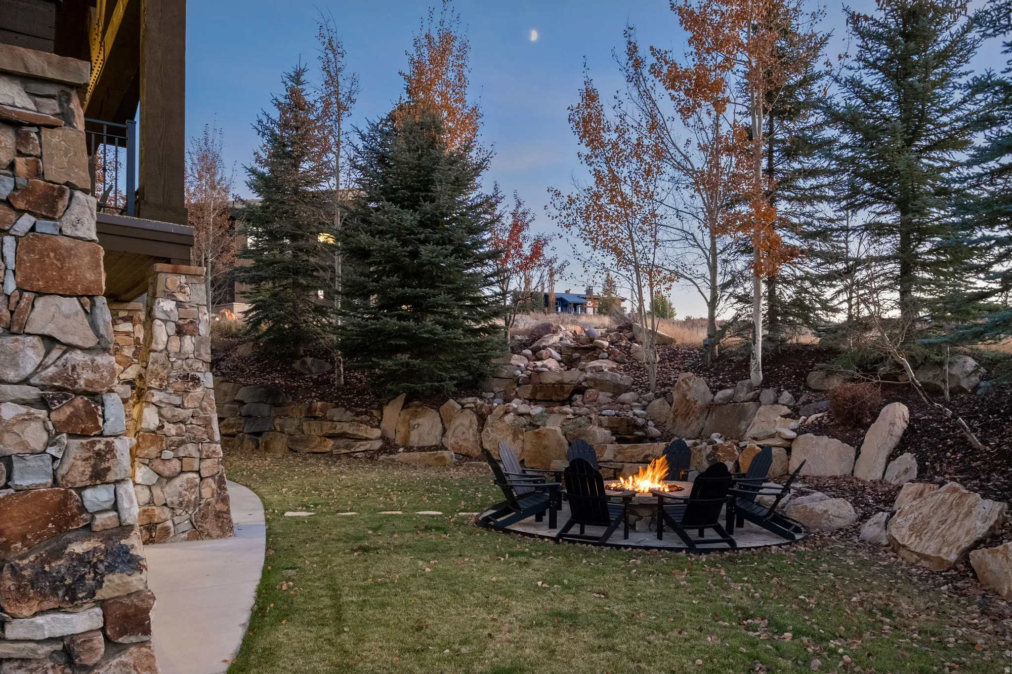 View of grassy yard featuring a patio area and a fire pit
